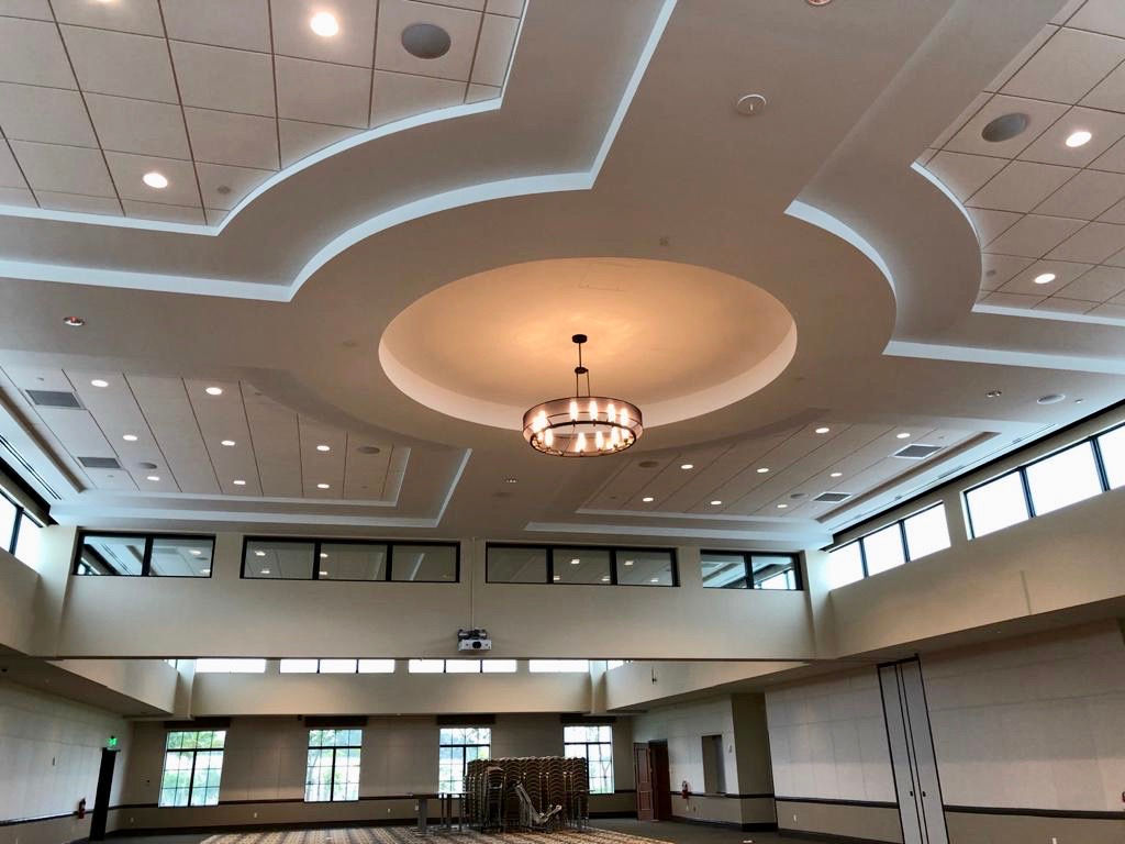 Event hall with geometric recessed ceilings and chandelier