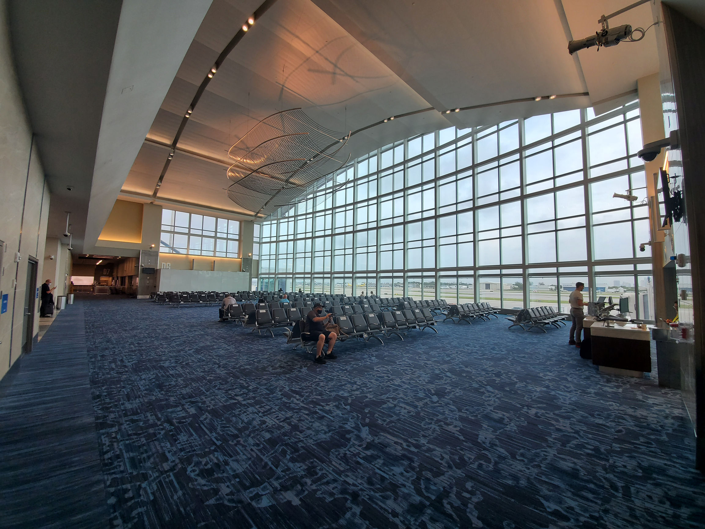 Airport waiting area with curved ceilings and expansive windows